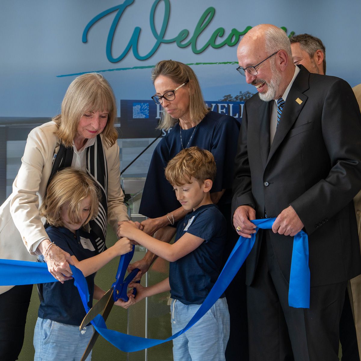 Dr. Johnson and some children cut the ribbon at the opening of the Roswell Park Scott Bieler Amherst Center