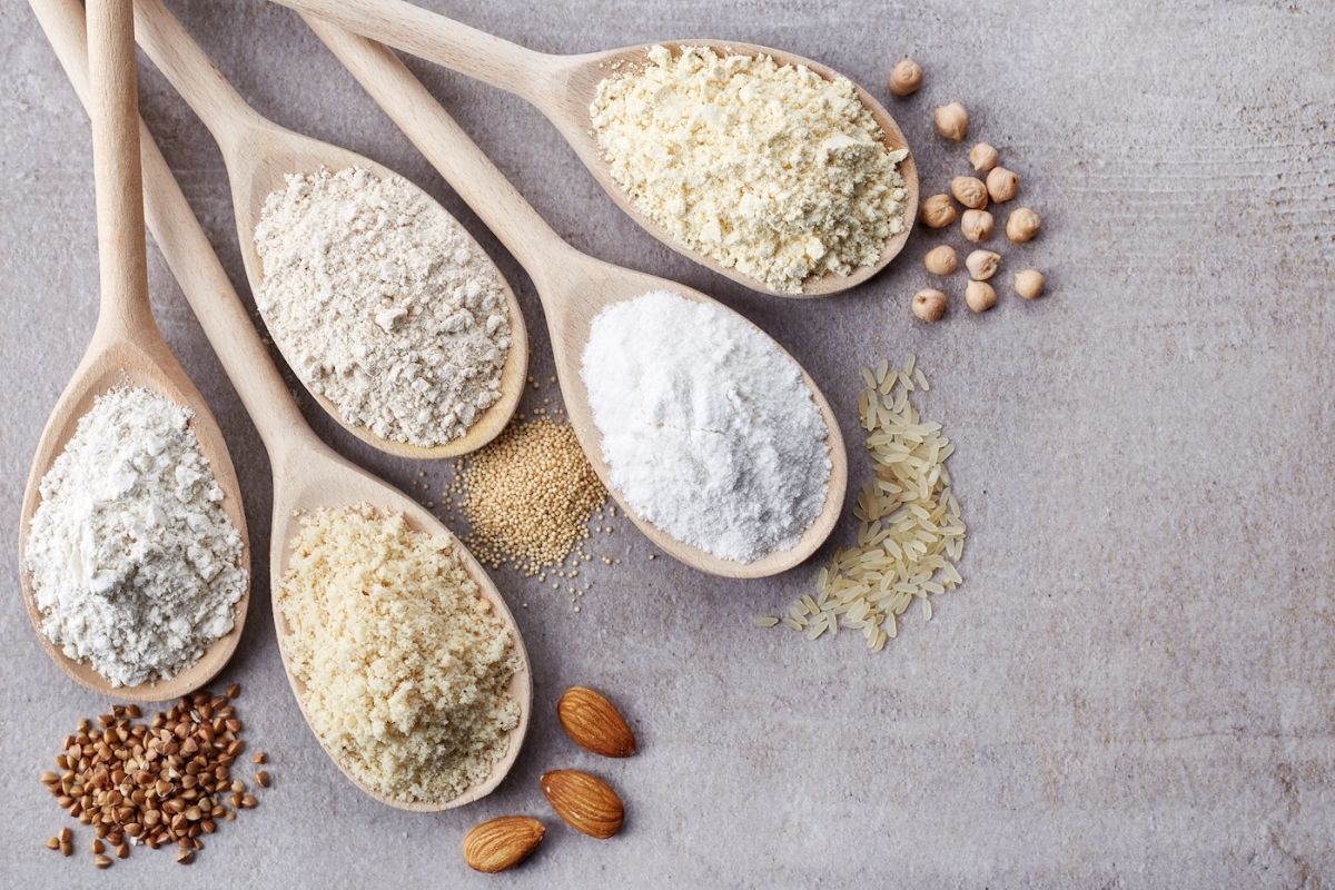Five different types of gluten free flours on baking spoons