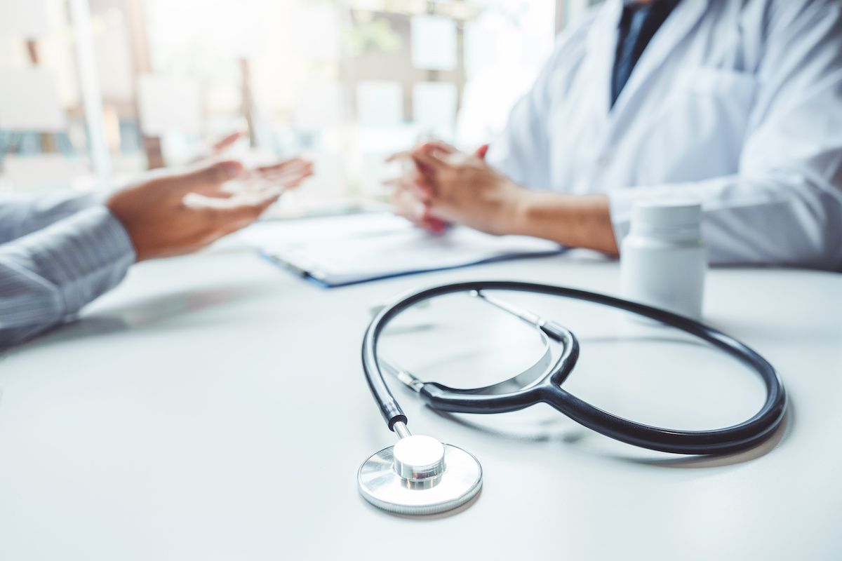 Doctor and patient talking together at a desk