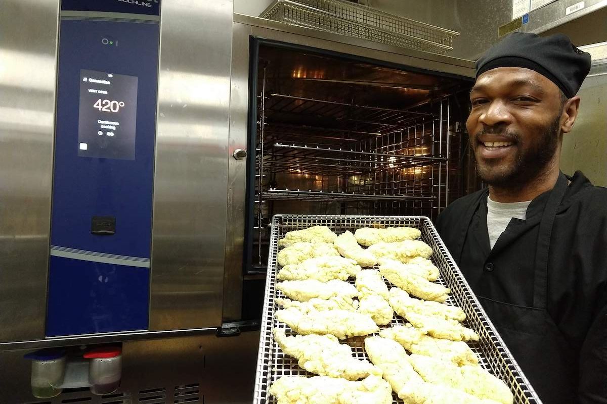 Lorenzo Clapp prepares a tray of chicken tenders for Roswell Park's new combination oven.