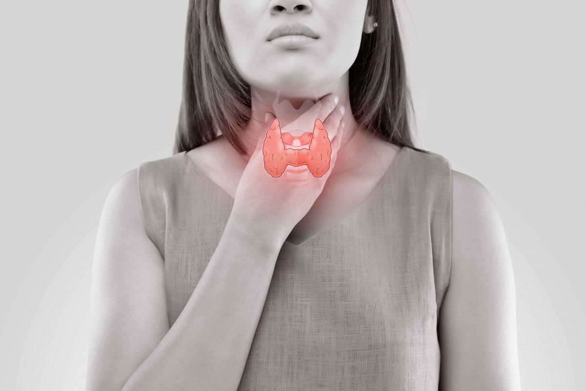 Women holding her throat with the thyroid gland highlighted in red