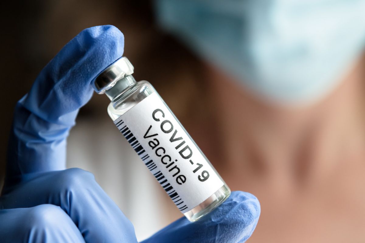 Hand holding a vial of COVID-19 vaccine