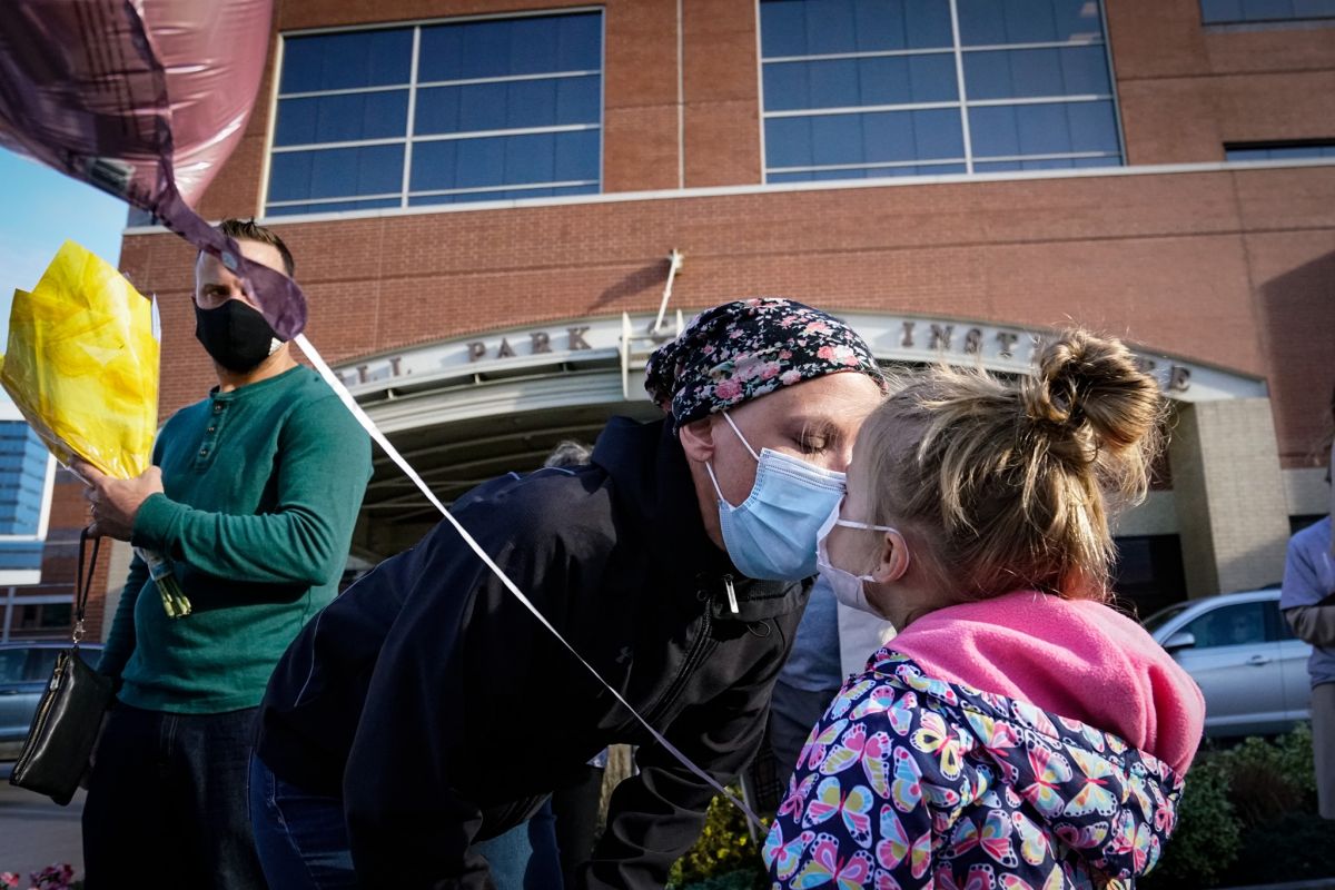 Kara Rowe shares a moment with her daughter after ringing the Victory Bell.