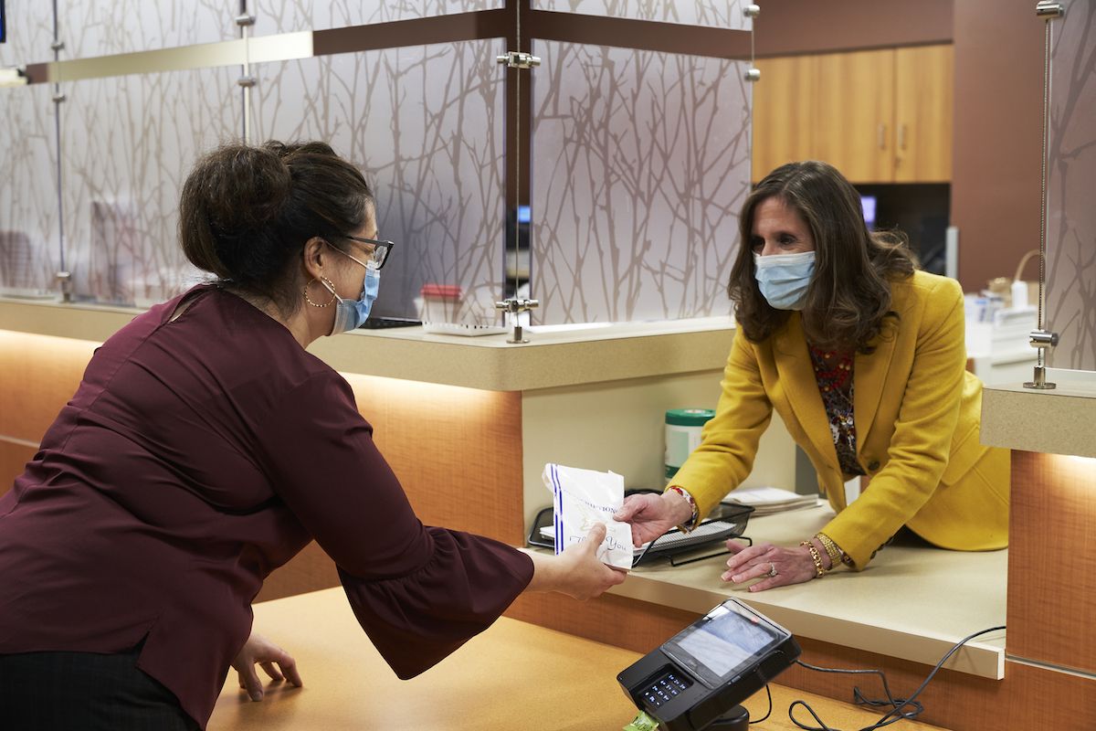 A Roswell Park pharmacist hands a prescription to a patient.