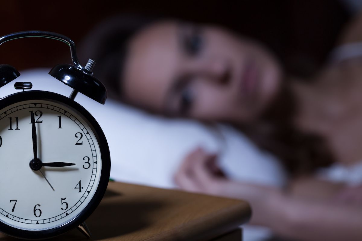 Woman looking at an alarm clock