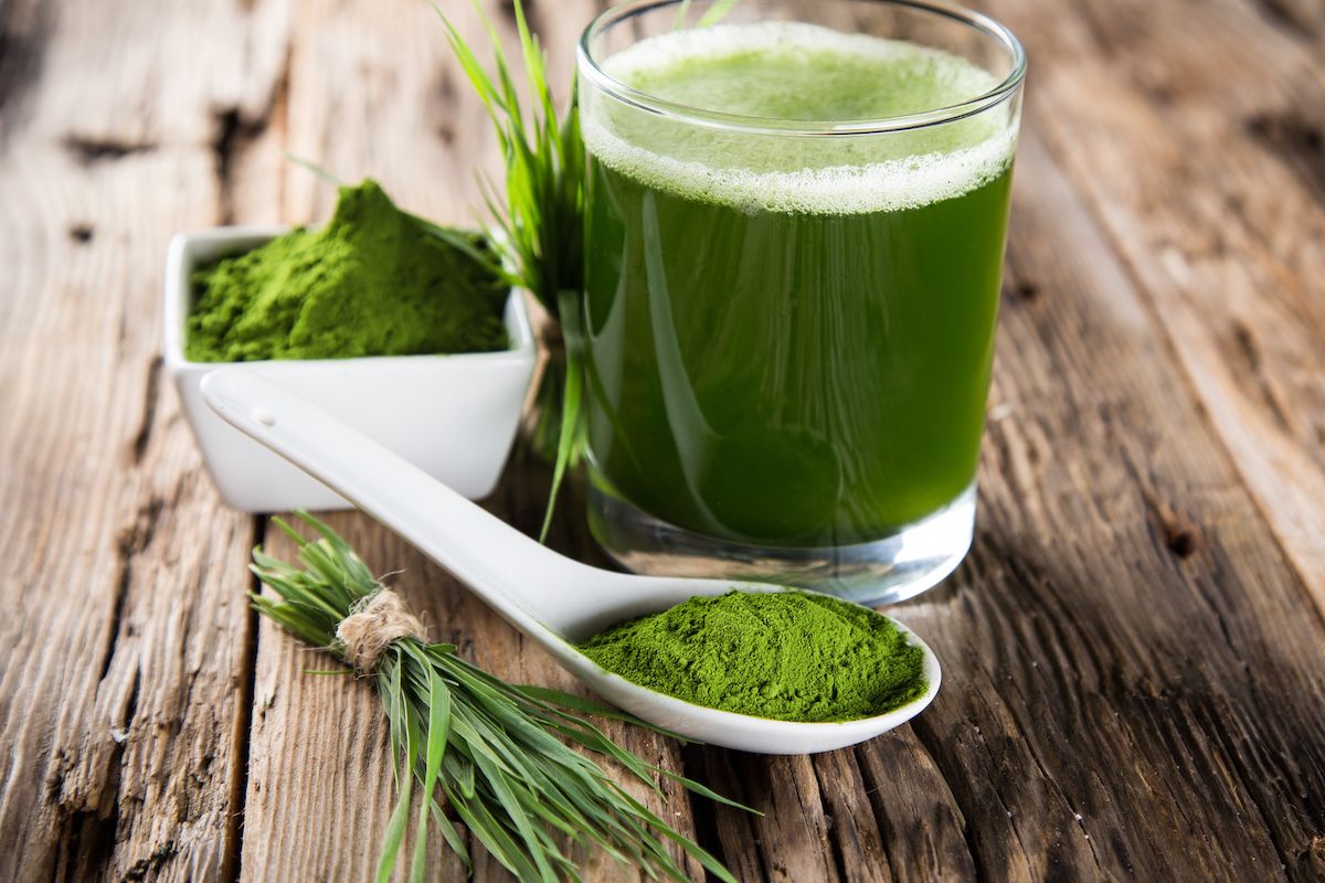 A cup of matcha tea sitting on a wooden plank