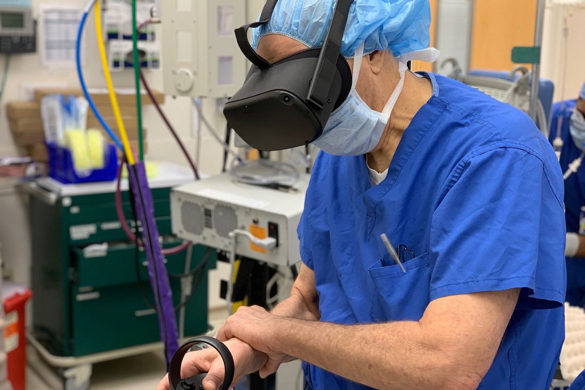 Doctor uses virtual reality goggles and controller to visualize tumor in the operating room before surgery.