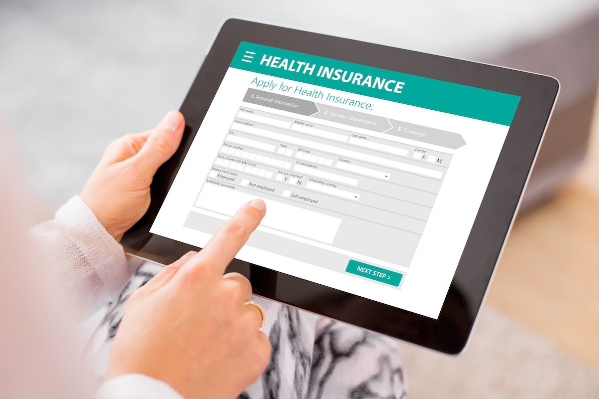 Person using a tablet to compare health insurance plans