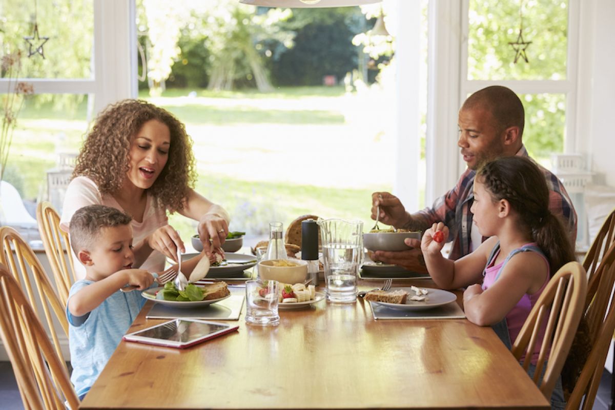 Family with two young children eating a meal in their kitchen