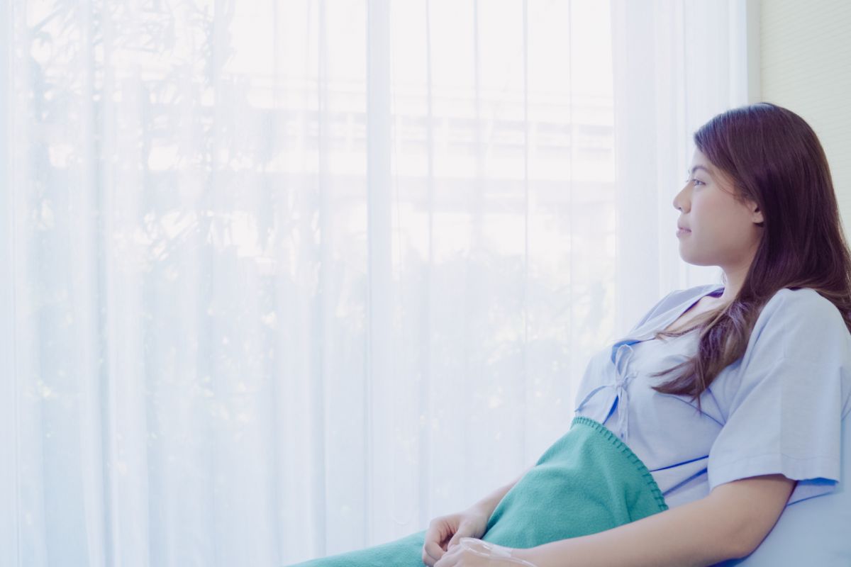 Patient sitting up in bed looking out a window