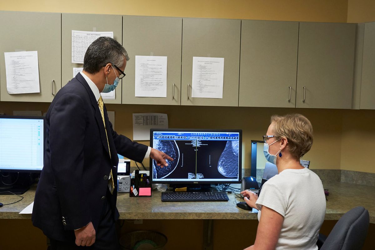 Dr. Crooks and Dr. Poss in front of mammogram image. 