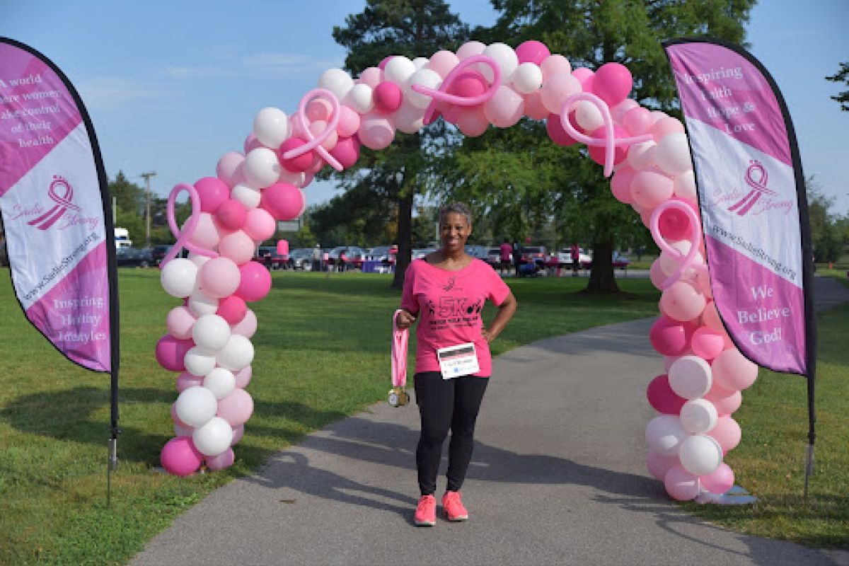 Sharon Sanford in front of pink balloon arch. 