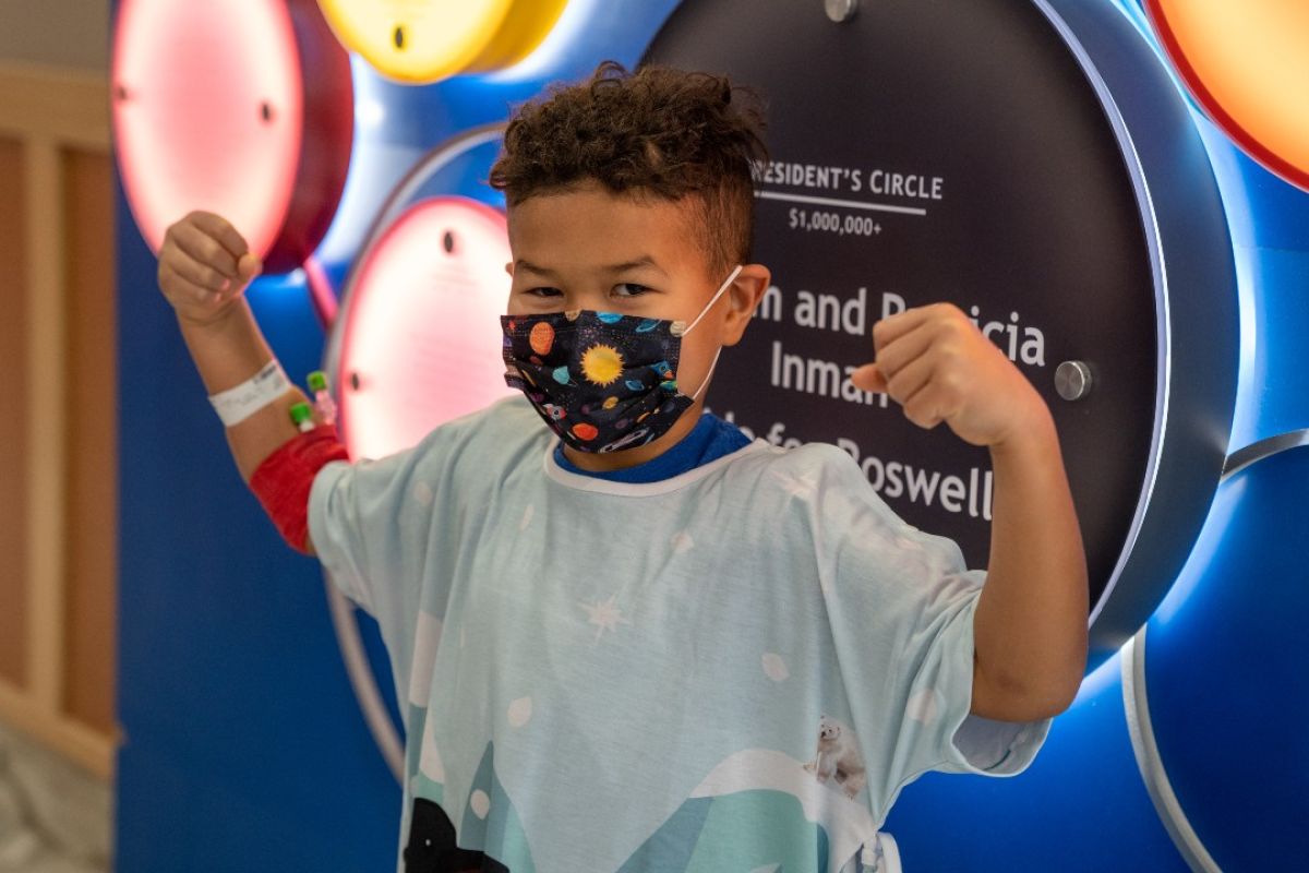 Andre 'The Warrior' Sanders shows off his signature flex while modeling a pediatric gown he designed.