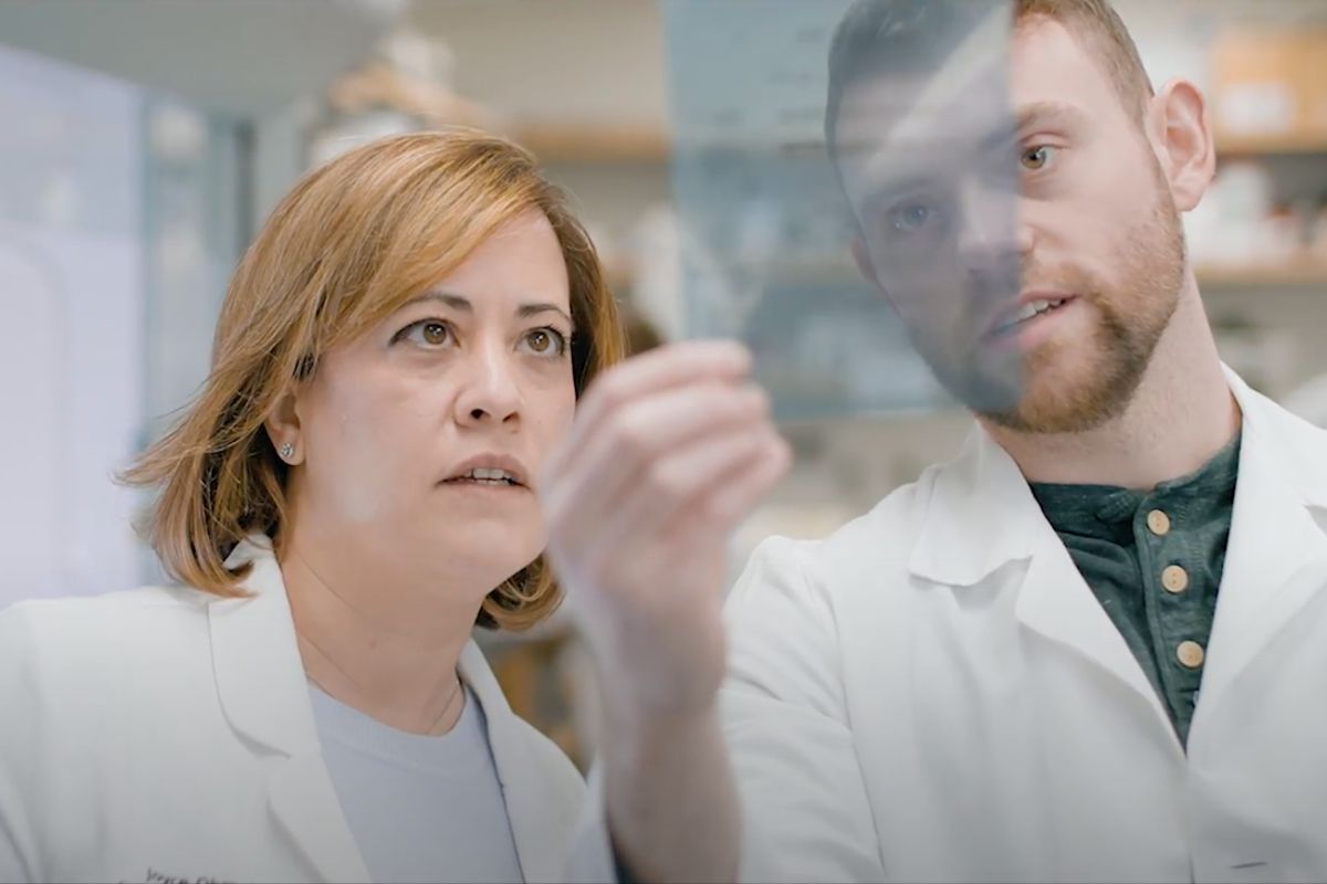 woman and man look at an item in the lab
