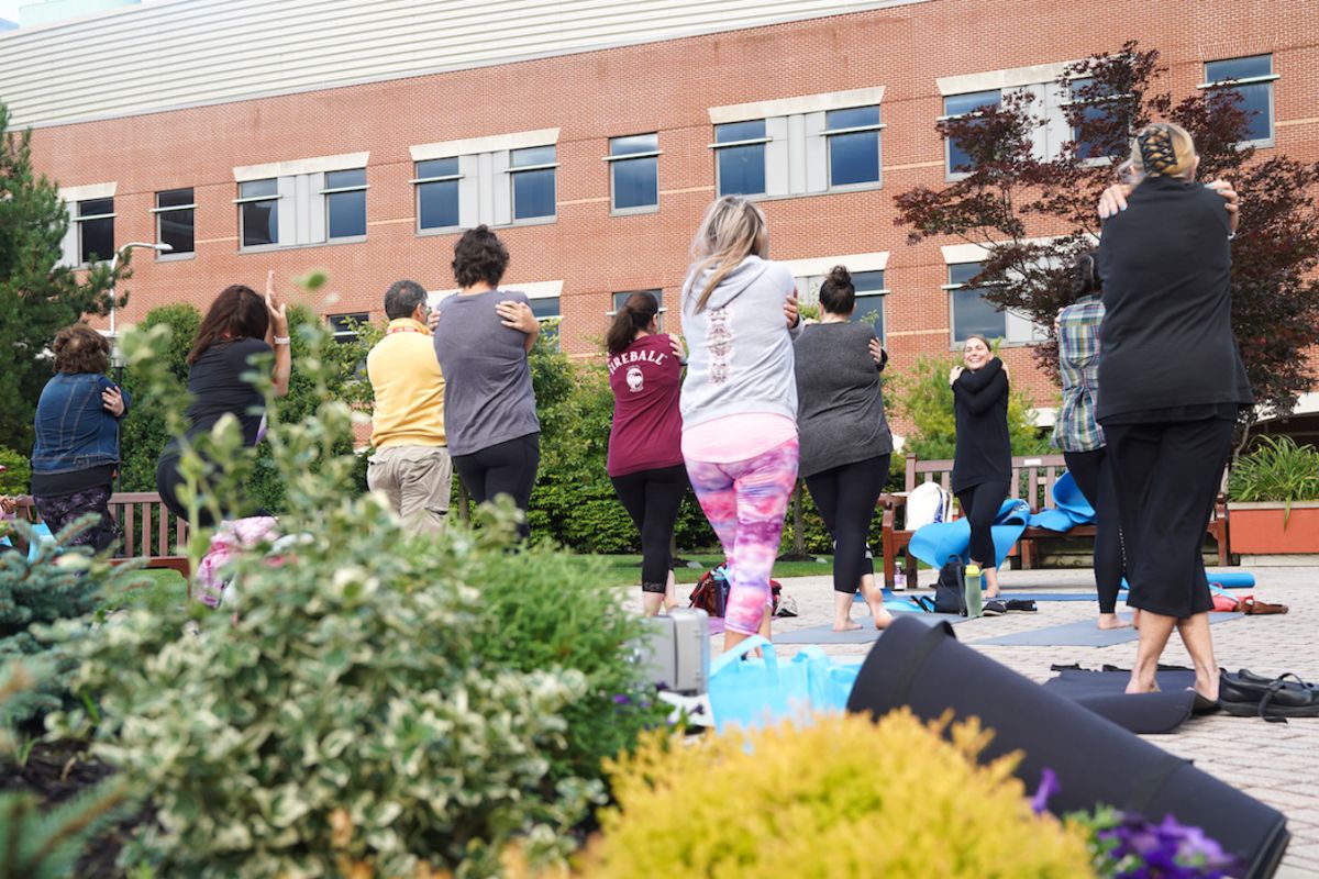 Dr. Kate Glaser leads a yoga session in the park at the Chapter 2 Cancer Survivorship Workshop 2019