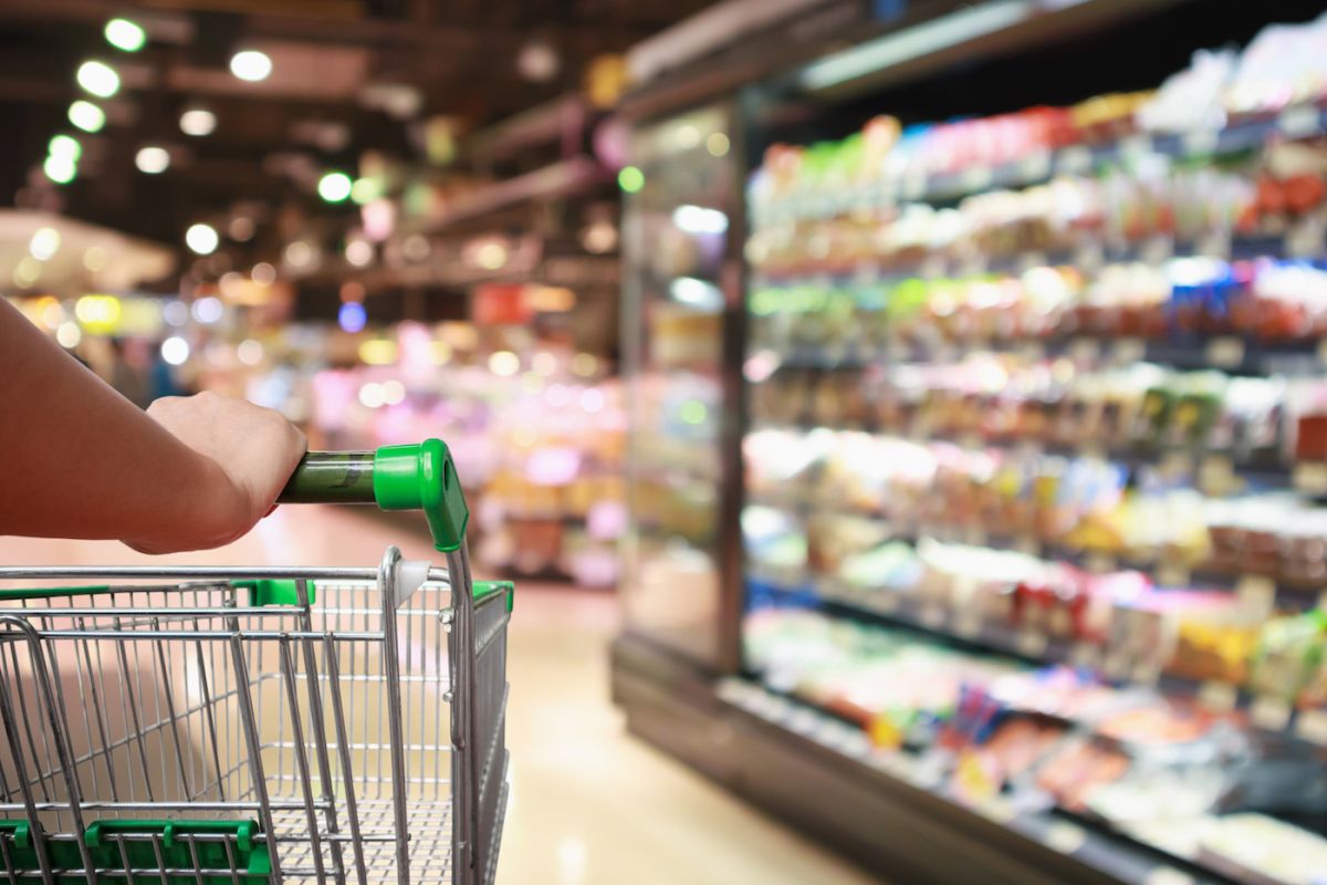 Shopping cart in a grocery aisle - stock