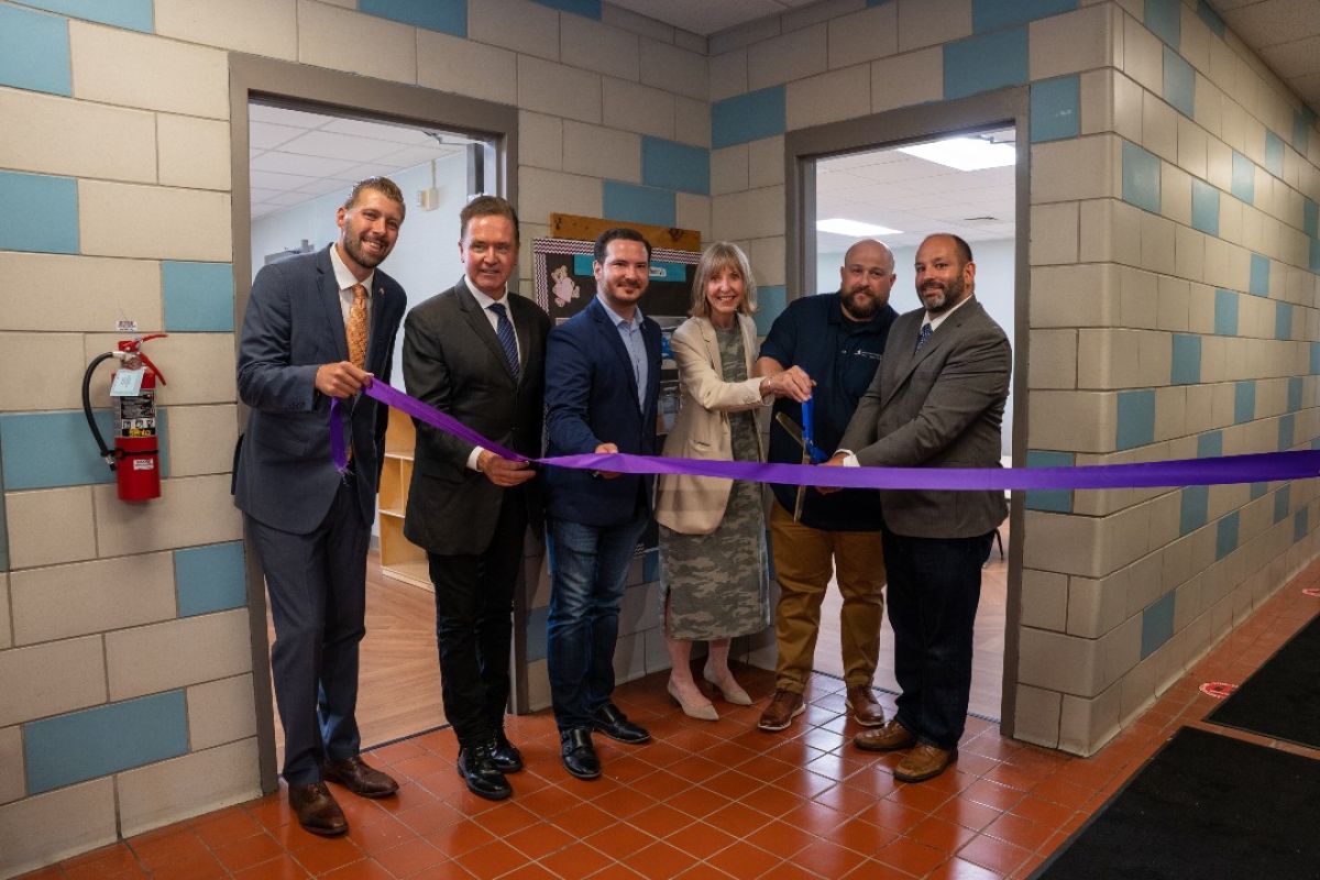 A group of elected officials join Candace Johnson, center, President and CEO of Roswell Park Comprehensive Cancer Center, along with leadership from Seneca Babcock Community Center and Buffalo Adult and Teen Challenge, to open new classrooms at Seneca Babcock. They hold a long purple ribbon.