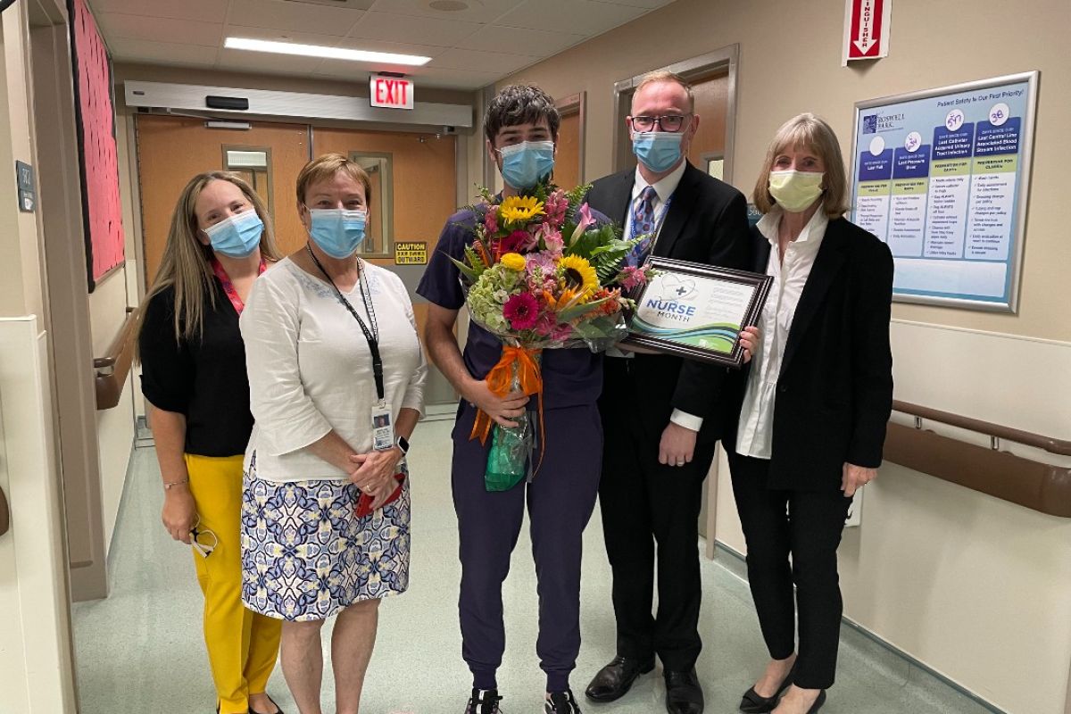 Tyler Russ, center, received flowers and a framed certificate in recognition of being named Nurse of the Month for September. 