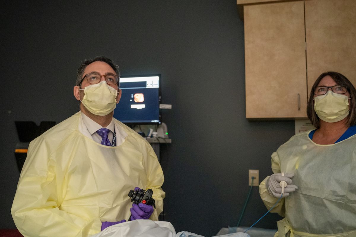 Dr. Anthony Dakwar in clinic performing a colonoscopy with a PA standing by