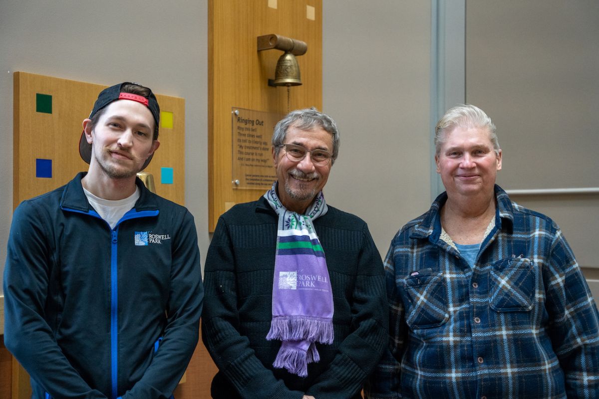 Nick Morrison, Paul Dublino and David Peek (from left) stand in front of the Victory Bell. 