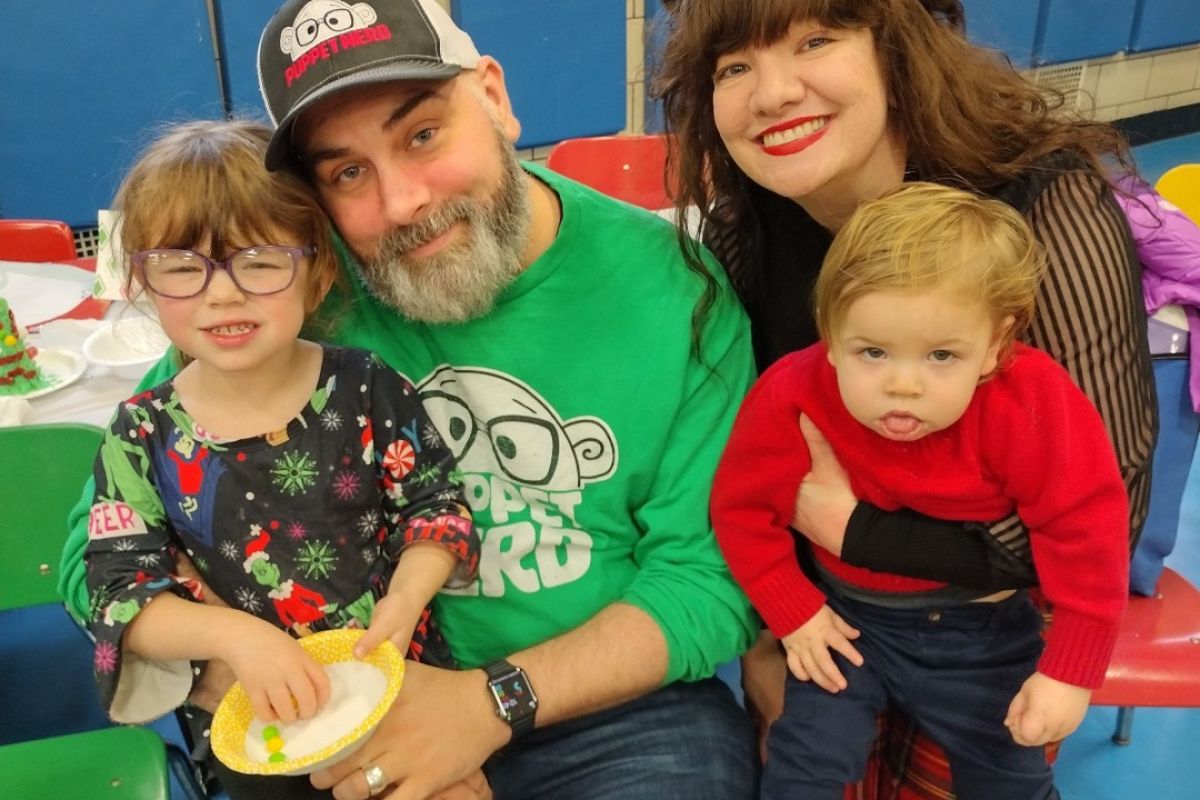 Adam and Maria Kreutinger, center, hold their two young children. 