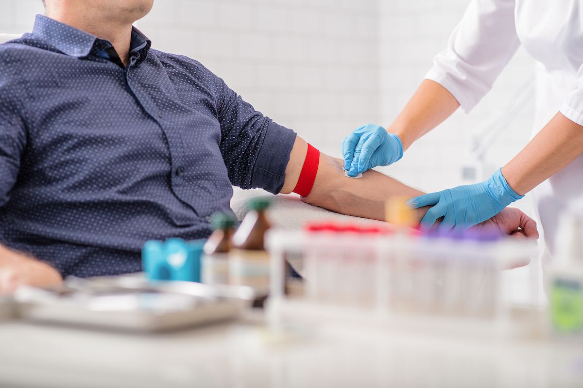 A nurse preps a man to donate blood 