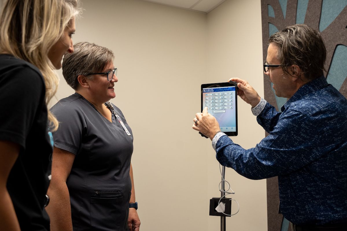 Brian Braun demonstrates how to use the new interpretation system, IRIS, to nurses Kayla Denea and Melissa Hiscock.