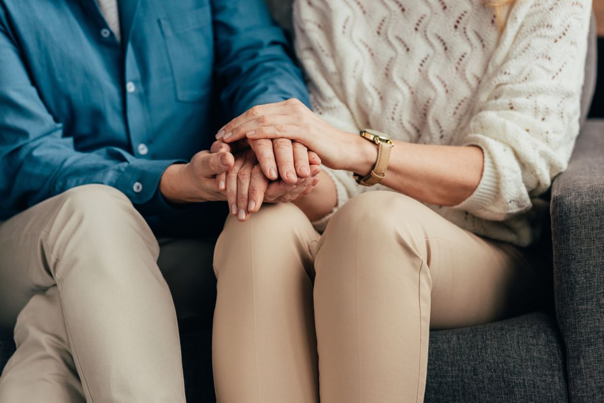 A couple sitting and holding hands