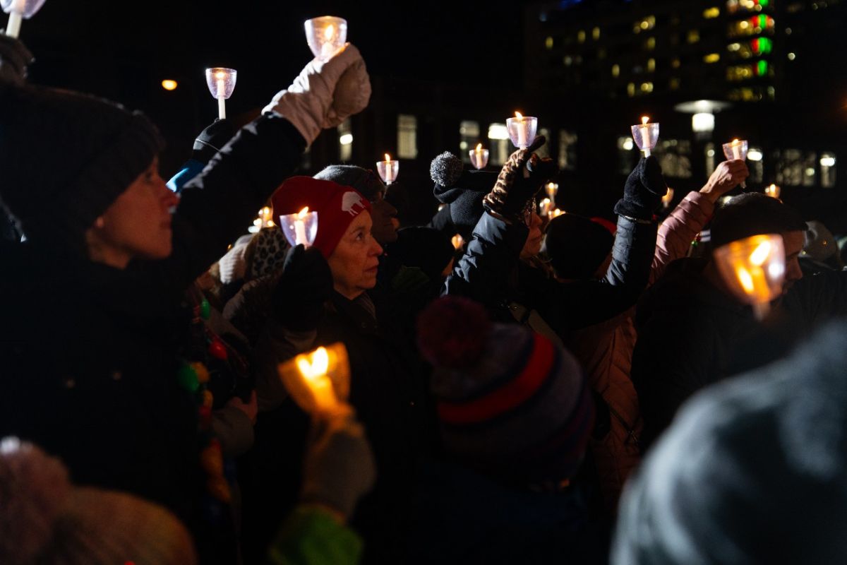 Attendees hold candles up in the air during the 2023 Tree of Hope ceremony. 