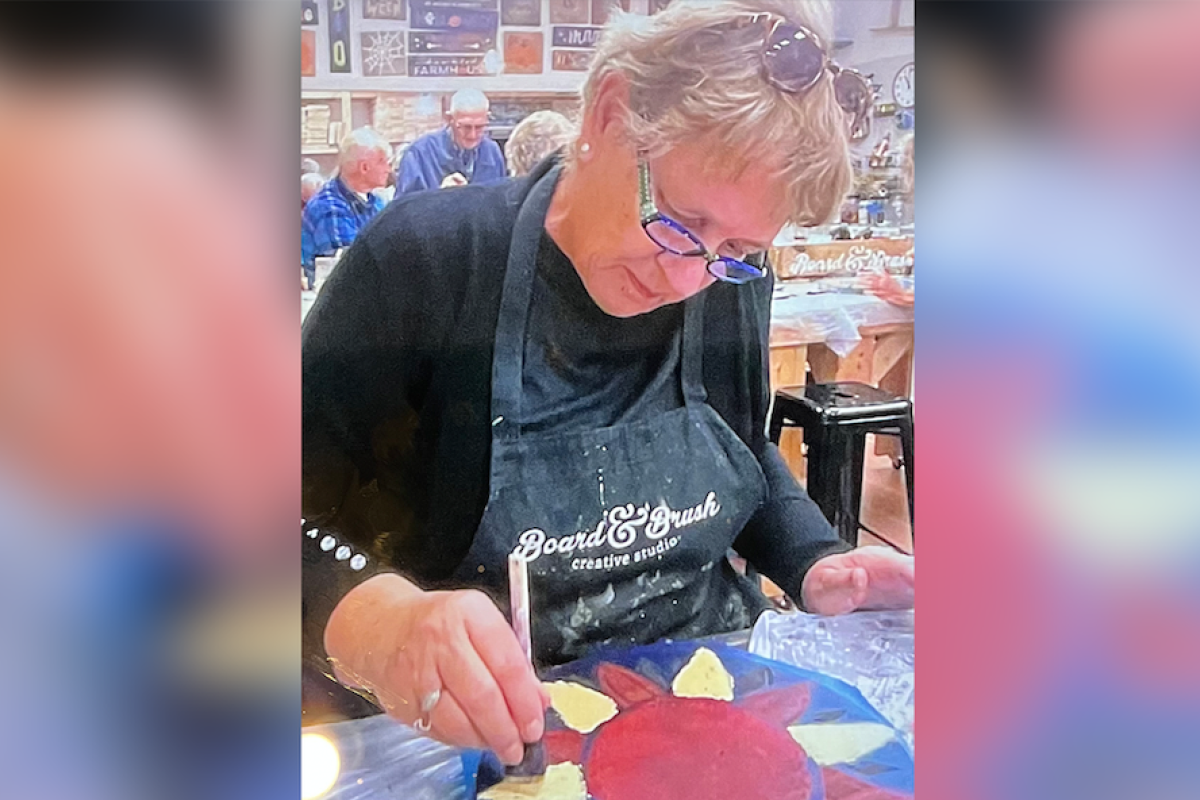 Marlea Brown, a colorectal cancer patient at Jamestown Medical Oncology, paints a picture of a flower