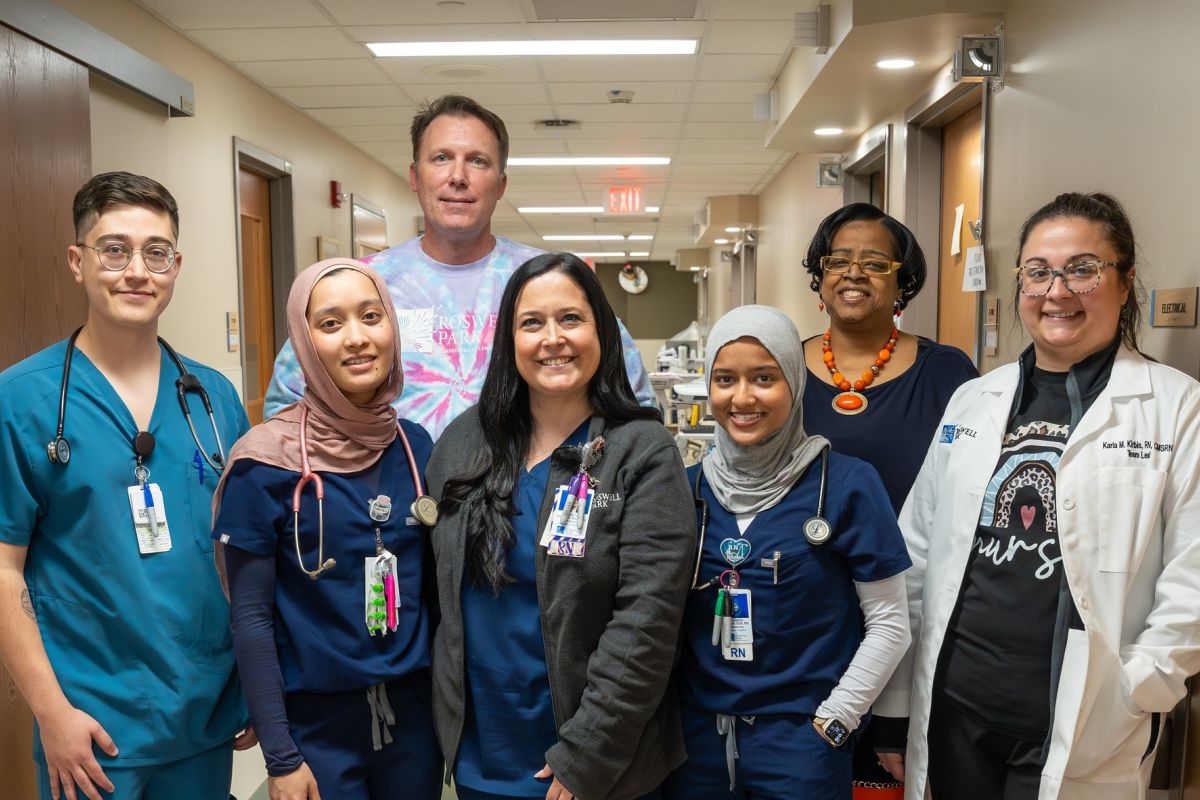 A group of nurses smile in a hallway