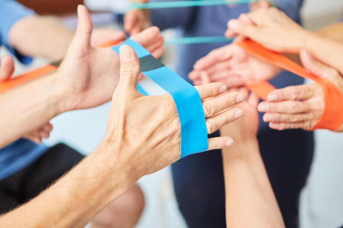 People using exercise bands on their hands for occupational therapy
