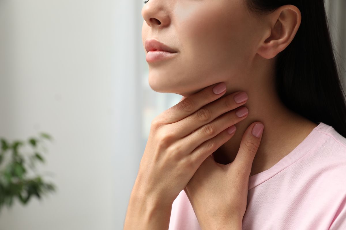 A woman holds her neck in pain