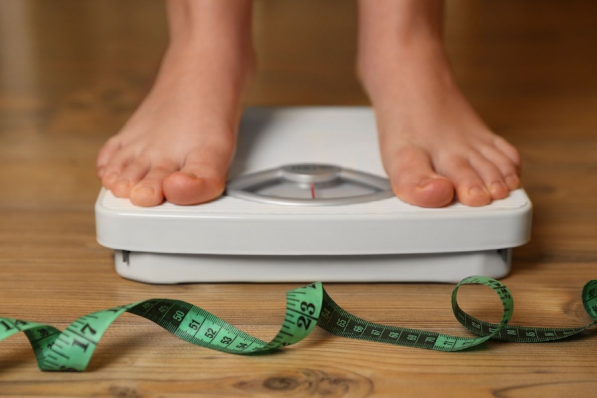Child's feet on scale with tape measure
