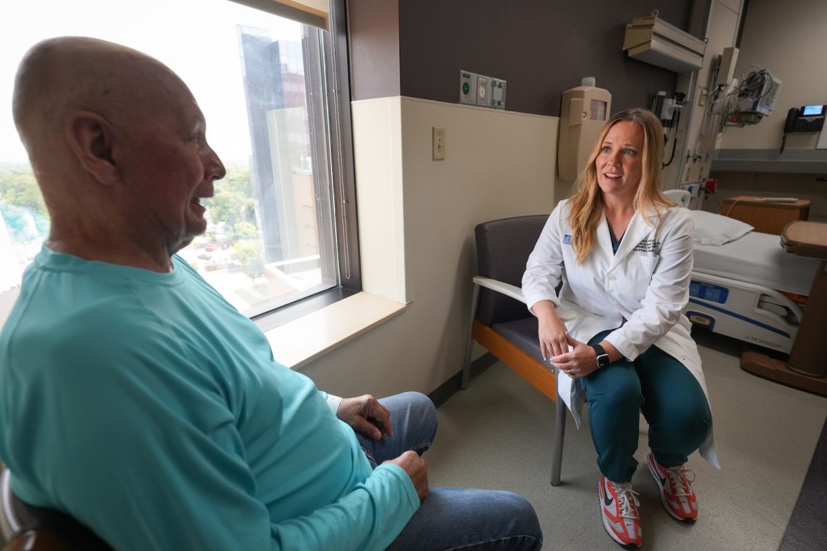 A doctor meets with a patient in their room