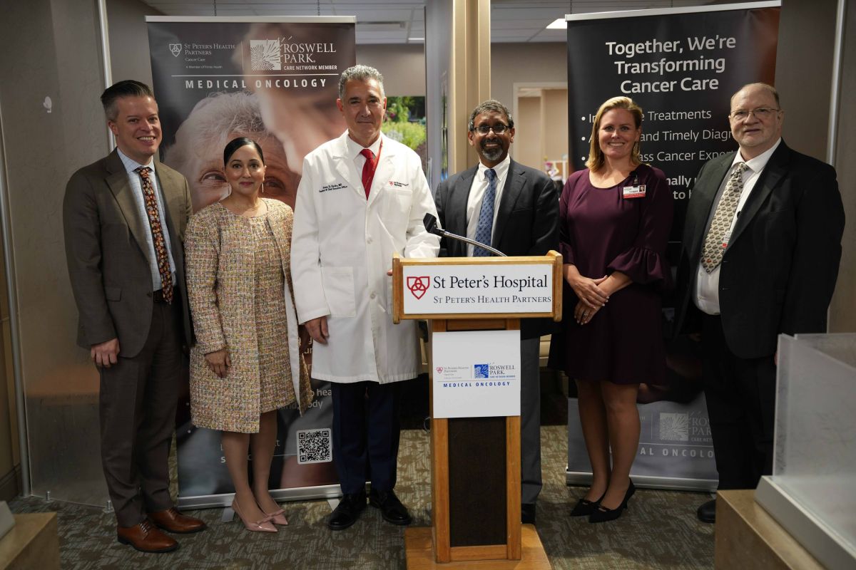 Leaders stand in front of podium for announcement