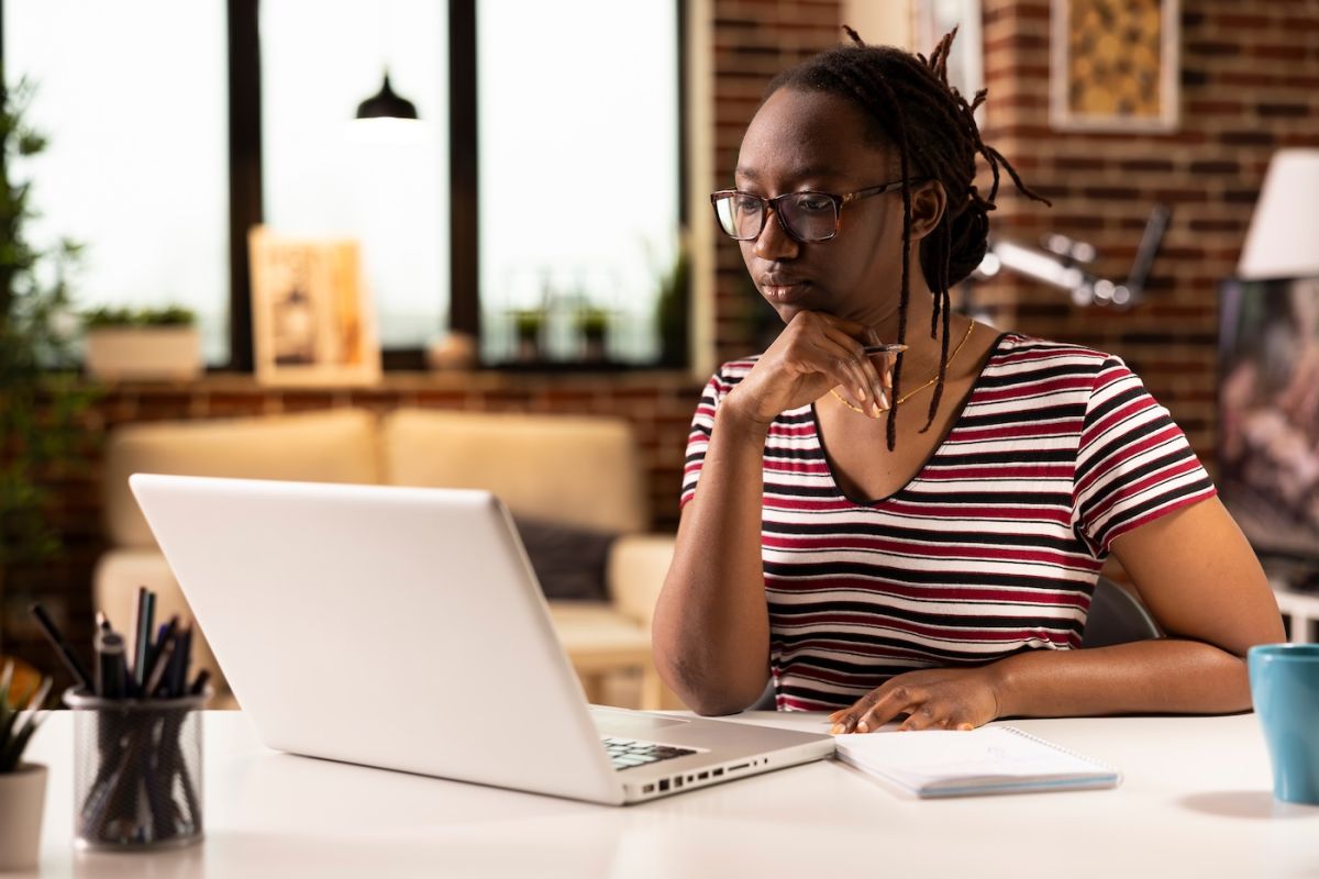 Woman sits in front of a computer attending a virtual meeting