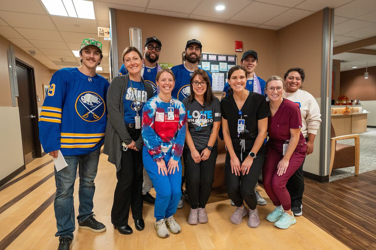 Hockey players pose for a photo with a group of nurses inside a hospital