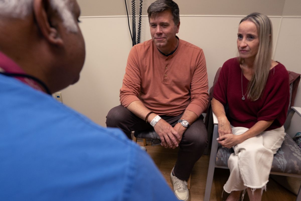 Husband and wife speak to doctor