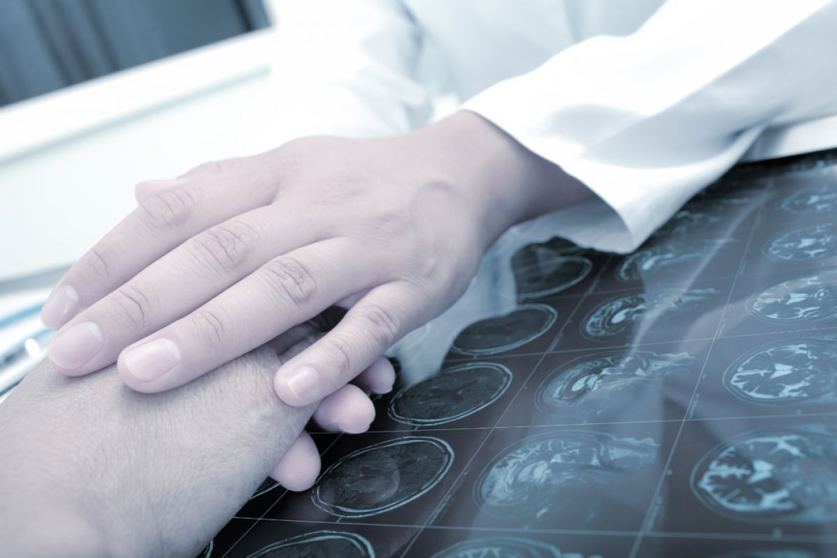 Two people holding hands over a sheet of x-rays