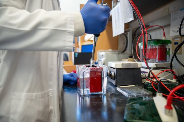 A hand filling a vial