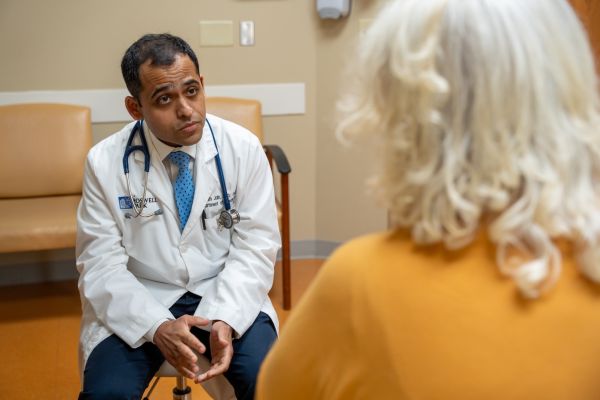 Dr. Prantesh Jain speaks with a female patient in clinic