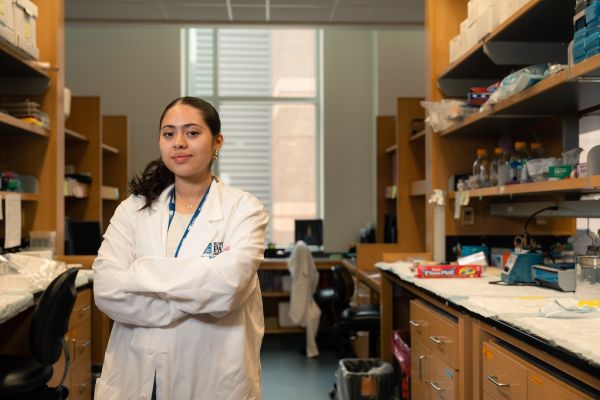 A female high school summer research student poses in a lab