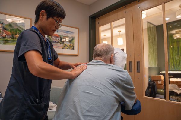 Massage therapist Yoshie Fanara gives a patient a shoulder massage in the 11 Day Power Play Cancer Resource Center