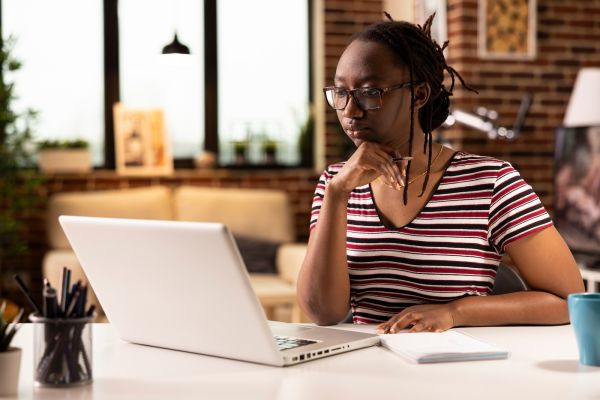Woman sits in front of a computer attending a virtual meeting