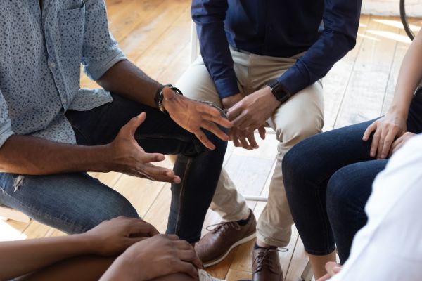 A man leads a group of caregivers in a session 