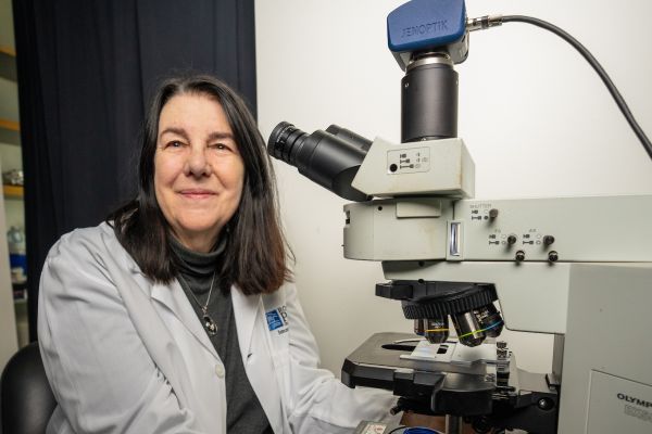 Woman sitting beside a microscope in a science lab