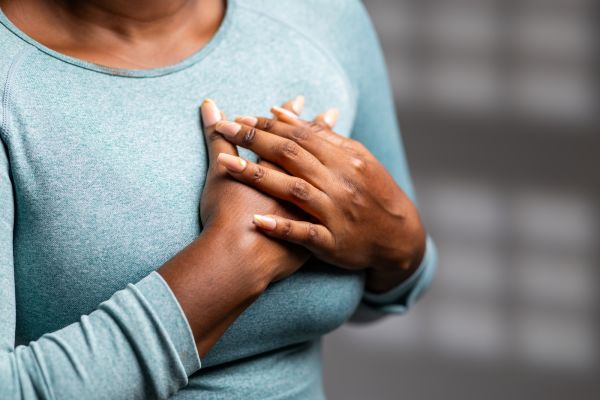A woman holds her hands over her chest
