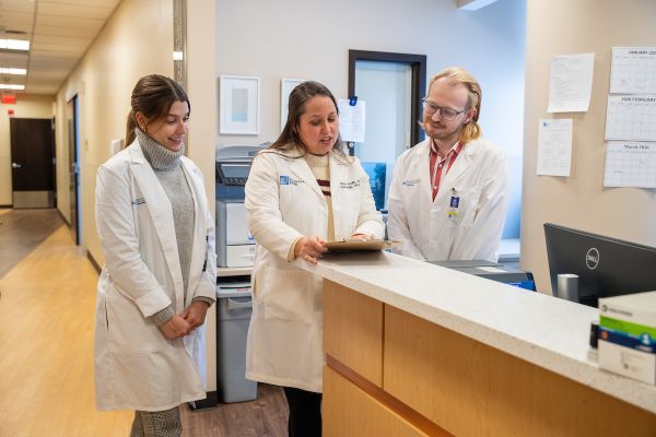 Dr. Nicole Gaulin collaborates with two gynecologic fellows in a hospital hallway