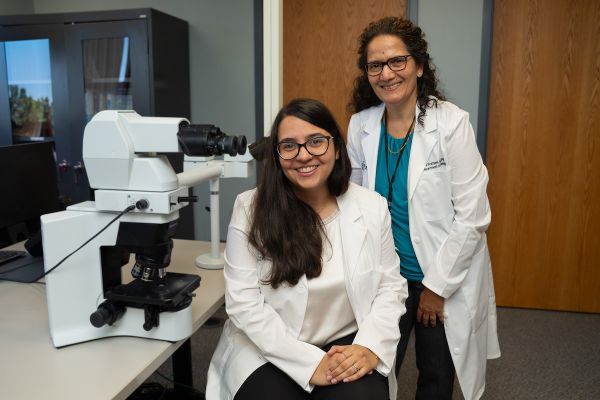 Dr. Saraswati Pokharel and cytopathology fellow Dr. Linnette Arroyo Roldan smile for a photo in the lab